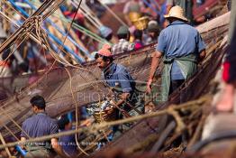 Image du Maroc Professionnelle de  Des ouvriers s'activent à réparer leurs filets de pêches
sur les bateaux au port de Laayoune, située à quelque kilomètre de la ville de Laayoune capitale du Sahara marocain, Vendredi 21 Septembre 2001. (Photo / Abdeljalil Bounhar) 